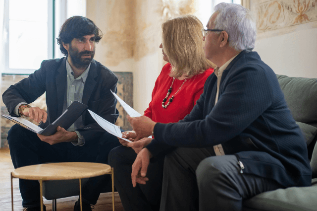 Couple holding papers talking with a financial officer