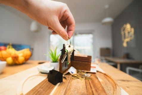 Hand holding a set of keys inside a house.