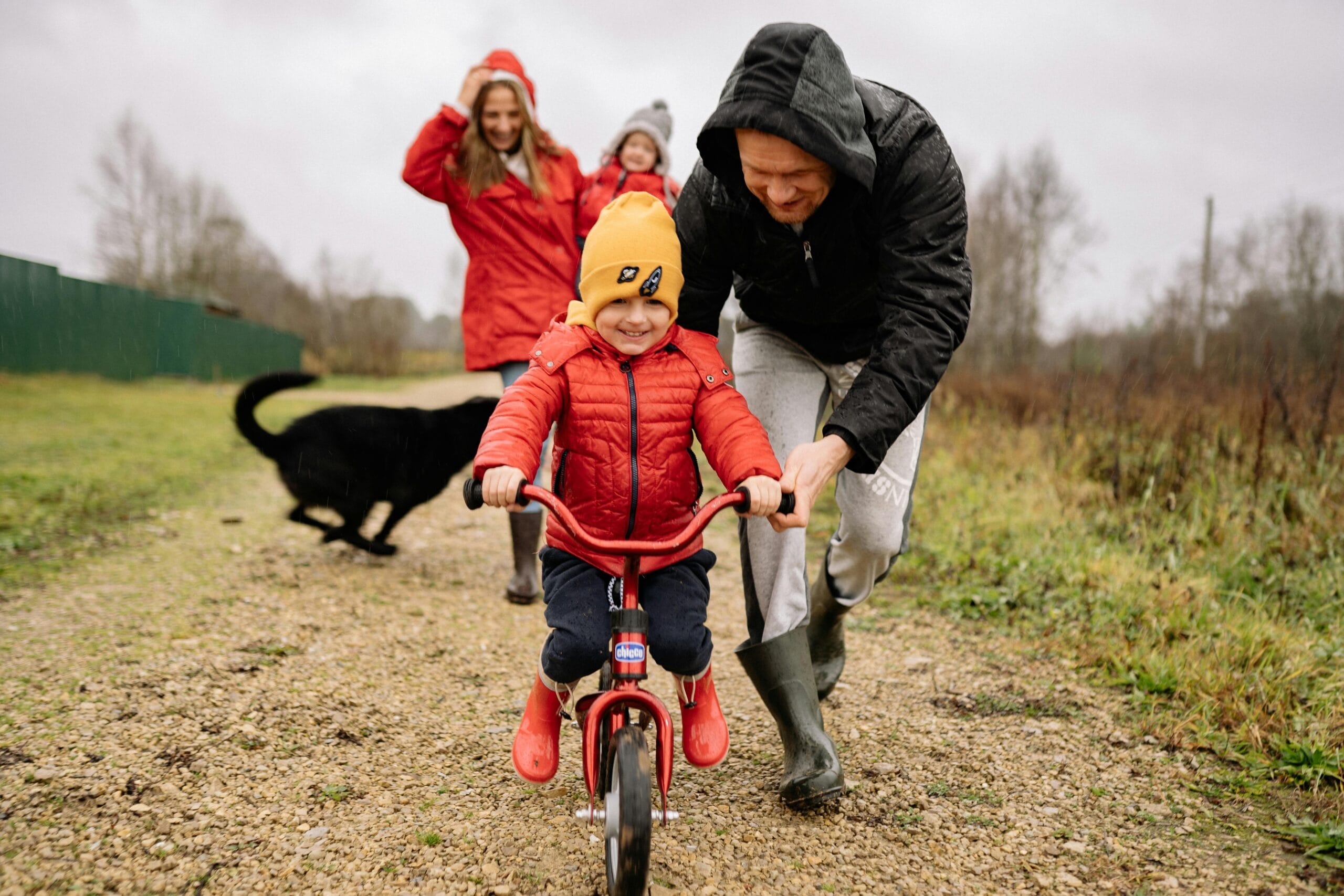 Child riding a bike outside with their family.