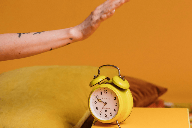 Hand about to hit an alarm clock.