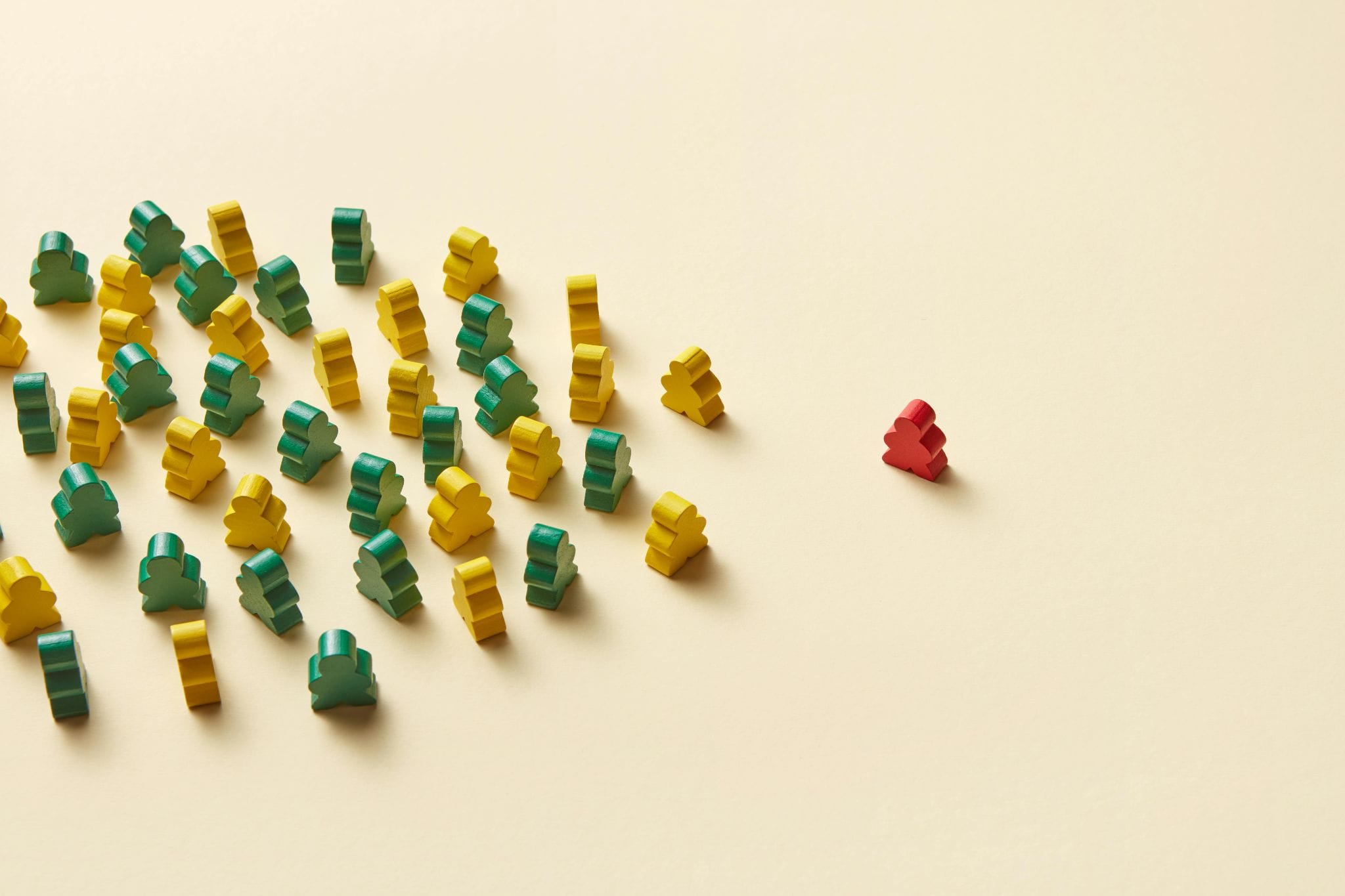 Red and yellow pawn pieces in a group. One red piece off on its own.