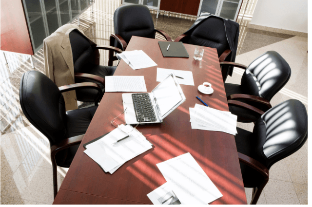 Large table in a conference room with papers.