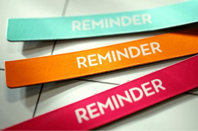 A blue, orange, and red strip of magnet that says "Reminder" on each one.